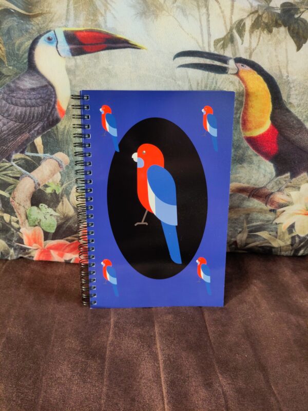 voorpagina notieboek 'vogelvlucht'. Kaft met vogel in het midden afgebeeld met een zwarte cirkel. De achtergrond van de kaft is paars en hier is dezelfde vogel nog 4 keer op afgebeeld.